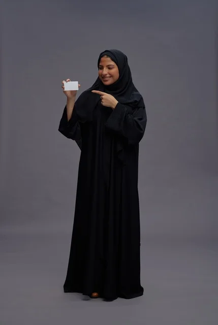 Saudi Woman in Abaya Holding Blank Card Saudi Woman in Abaya Holding Blank Card