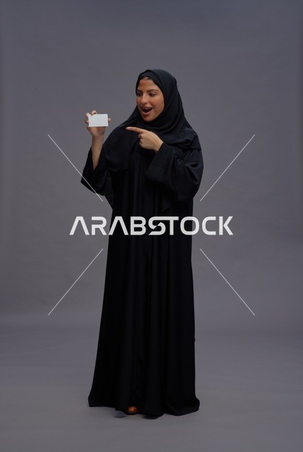 امرأة سعودية بالعباءة السوداء تحمل بطاقة فارغة