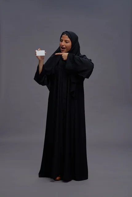 Saudi Woman in Black Abaya Pointing at Blank Card