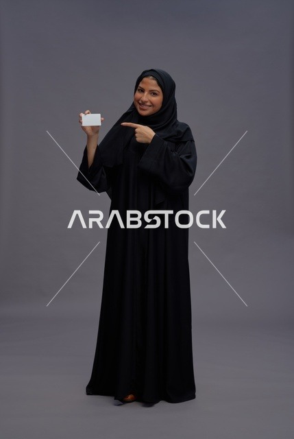 امرأة سعودية بعباية تحمل بطاقة فارغة