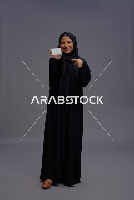 امرأة سعودية بعباية سوداء تحمل بطاقة فارغة