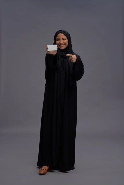 امرأة سعودية بعباية سوداء تحمل بطاقة فارغة