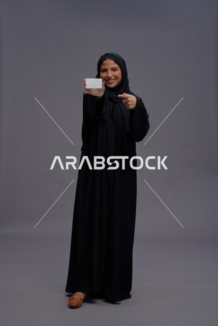 امرأة سعودية بعباية سوداء تحمل بطاقة فارغة