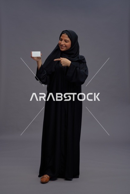 امرأة سعودية بعباية سوداء تحمل بطاقة فارغة