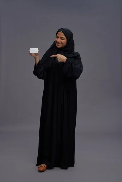 امرأة سعودية بعباية سوداء تحمل بطاقة فارغة