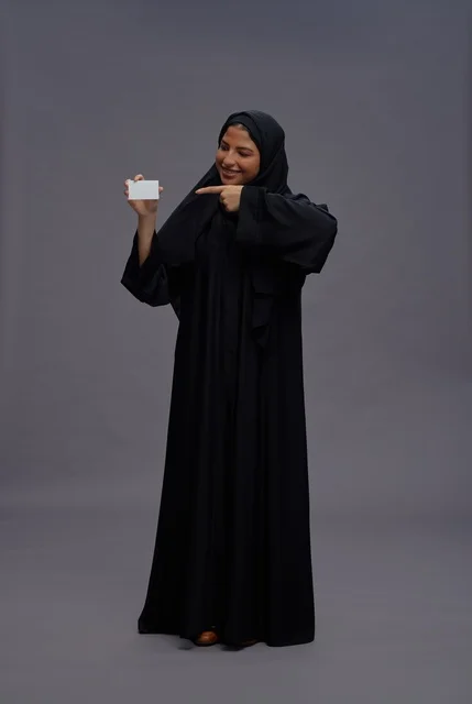 امرأة سعودية بعباية سوداء تحمل بطاقة فارغة