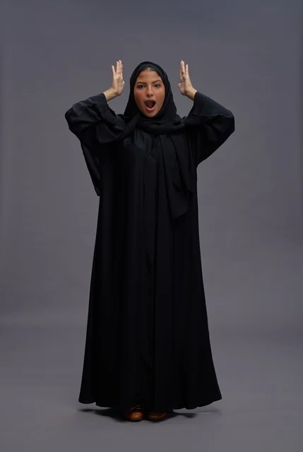 Excited Saudi Woman in Black Abaya on Gray Background