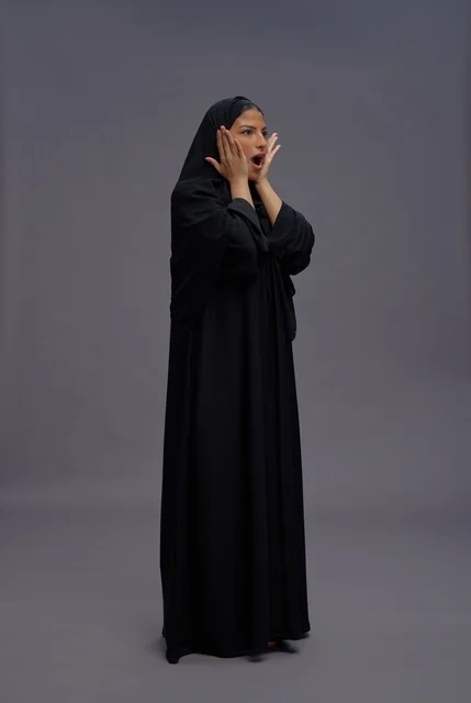 امرأة سعودية بعباية سوداء مع تعبير وجه مندهش