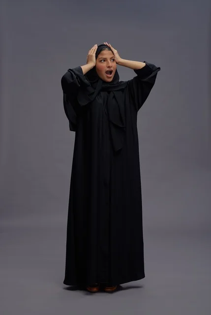 امرأة سعودية بعباية سوداء بتعبير وجه مندهش