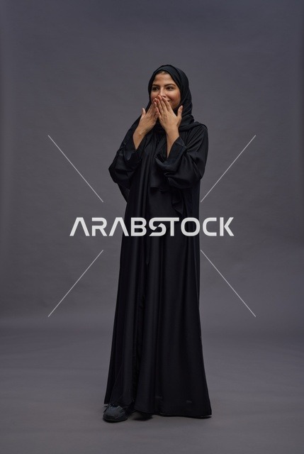امرأة سعودية مبتهجة بالعباية السوداء في استوديو