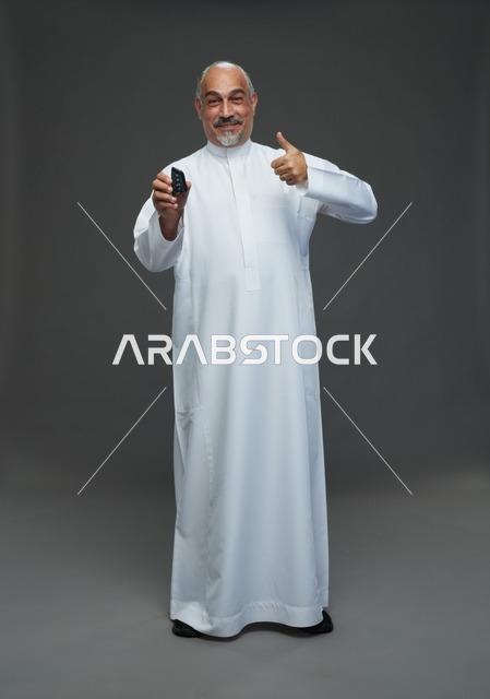 رجل سعودي مع مفتاح سيارة وعلامة النجاح