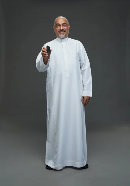 رجل سعودي مسن يرتدي ثوباً أبيض يحمل مفتاح سيارة