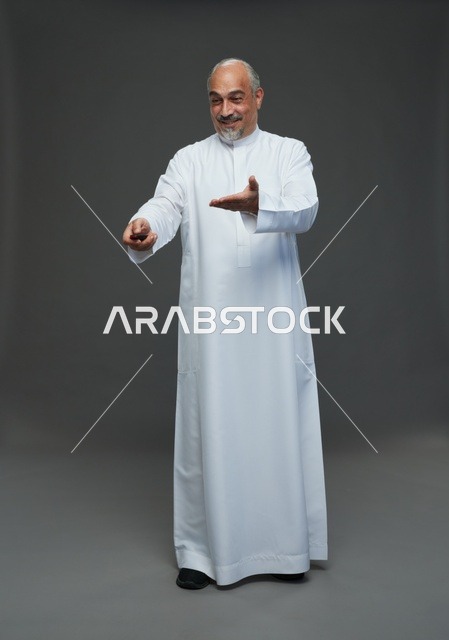 رجل سعودي مسن يحمل مفتاح سيارة ويرتدي الثوب الأبيض