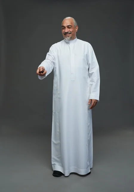 رجل سعودي مسن يحمل مفتاح سيارة في الاستوديو