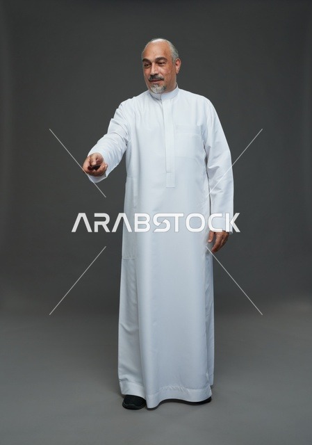 رجل سعودي مسن يحمل مفتاح سيارة في الاستوديو