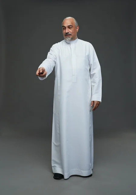 رجل سعودي مسن يحمل مفتاح سيارة في الاستوديو