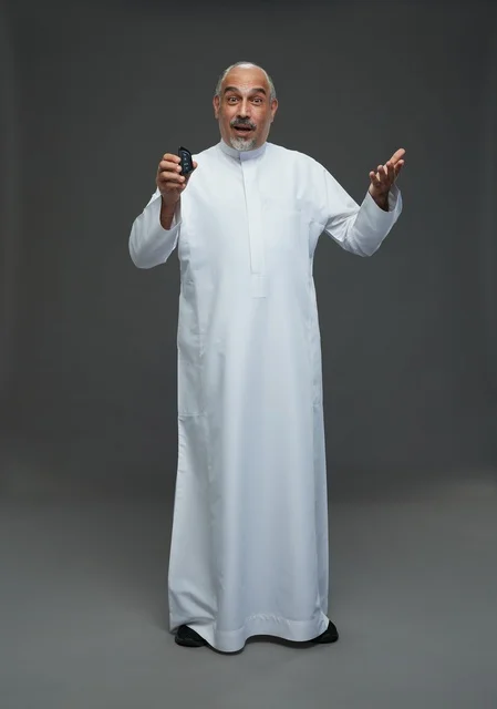 Elderly Saudi Man Holding Car Key on Grey Background