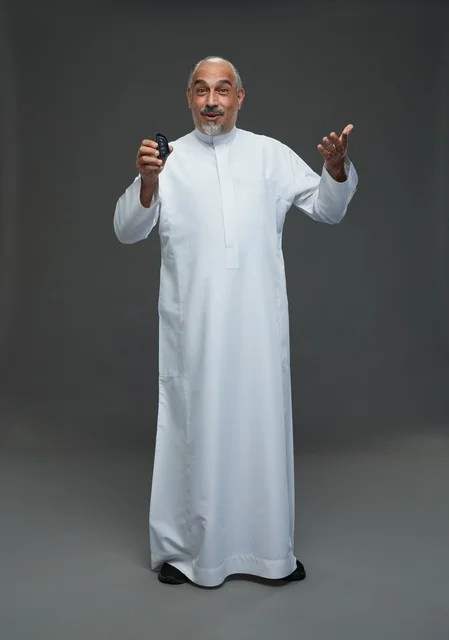 رجل سعودي مسن يحمل مفتاح سيارة في الاستوديو