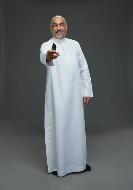 Saudi Senior Man Holding Car Key on Grey Background