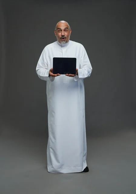 Senior Saudi Man with Digital Tablet on Grey Background