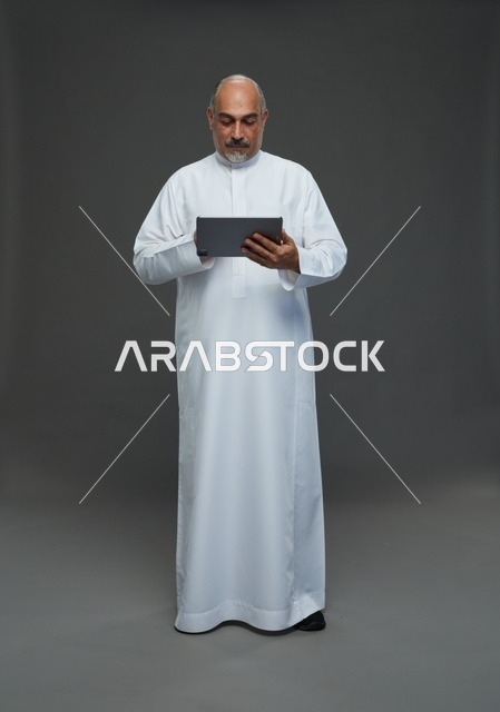 Elderly Saudi Man Using Tablet in Studio