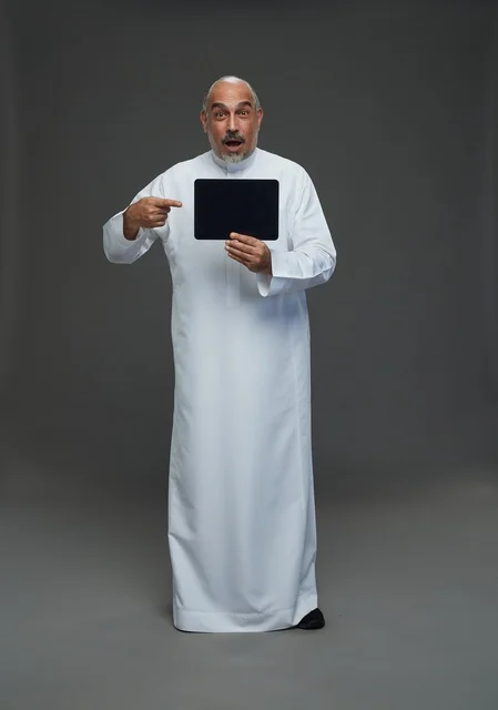 Senior Saudi Man Holding Tablet with Surprised Face