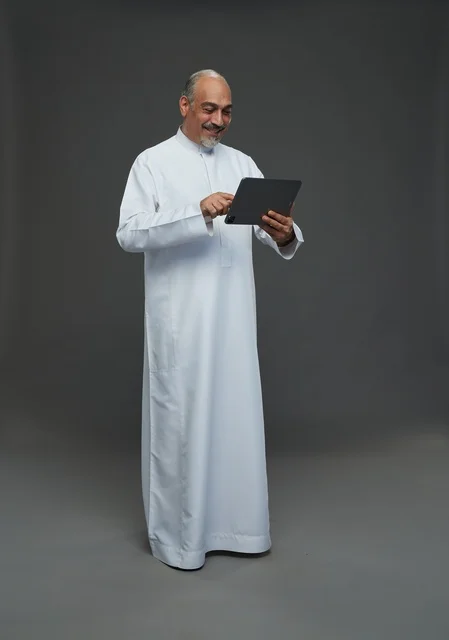 Elderly Saudi Man Using Digital Tablet in Studio