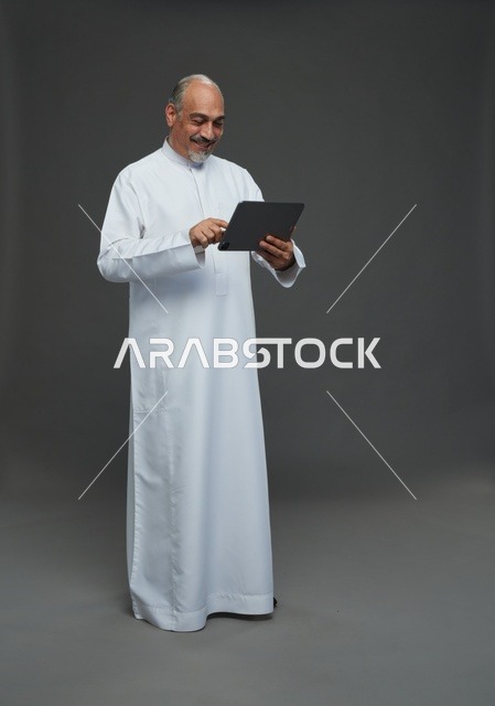 Senior Saudi Man Using Digital Tablet in Studio Portrait