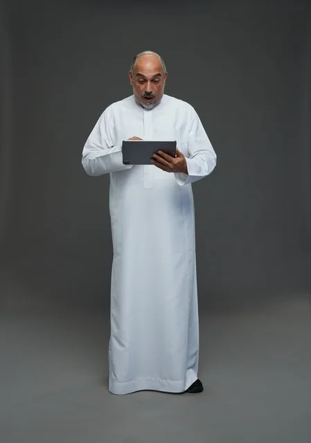 Elderly Saudi Man using Digital Tablet with Surprised Face