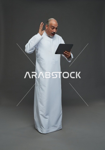 Elderly Saudi Man Using Digital Tablet in Studio