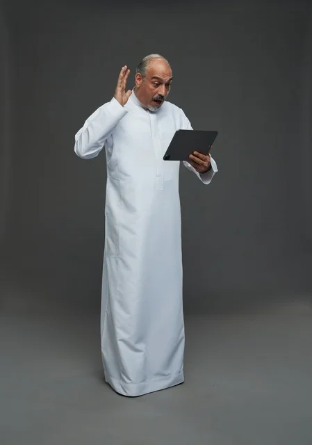 Elderly Saudi Man Using Digital Tablet in Studio Elderly Saudi Man Using Digital Tablet in Studio