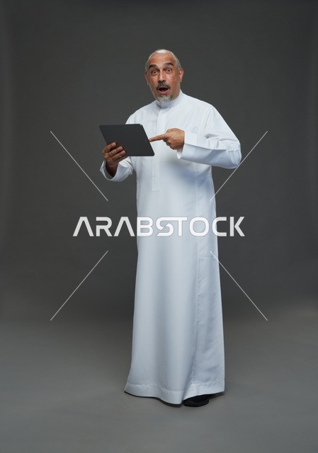Senior Saudi Man Using Tablet with Surprised Expression