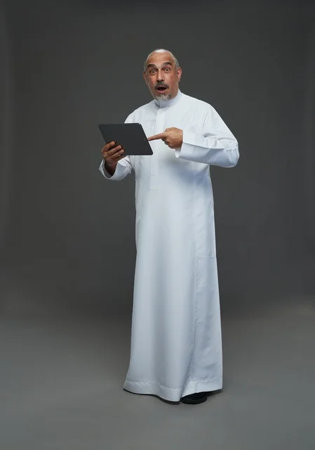Senior Saudi Man Using Tablet with Surprised Expression