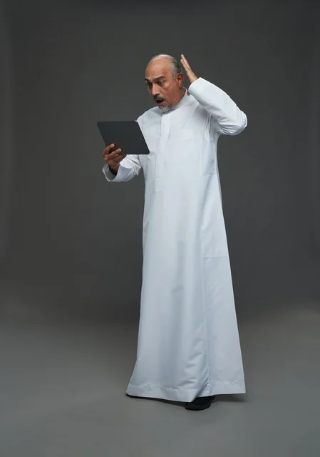 Elderly Saudi Man Using Tablet with Shocked Expression