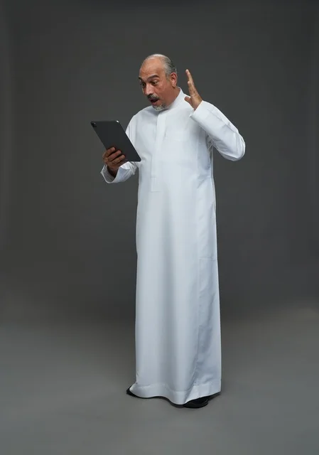 Surprised Elderly Saudi Man Using Tablet in Studio