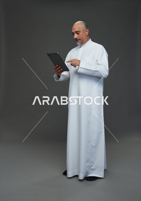 Elderly Saudi Man Using Digital Tablet in Studio