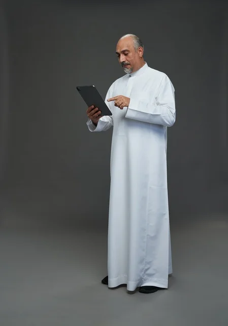Elderly Saudi Man Using Digital Tablet in Studio