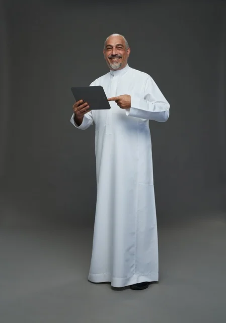 Senior Saudi Man with Tablet on Grey Background