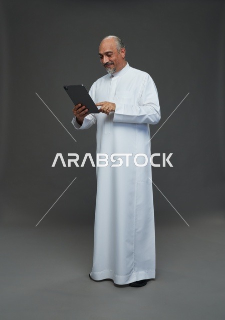 Elderly Saudi Man Using Digital Tablet in Studio