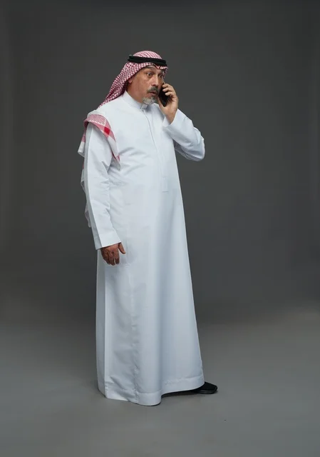 رجل سعودي مسن يتحدث بالهاتف في استوديو