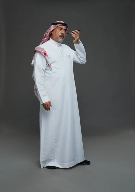 Elderly Saudi Man Using Smartphone in Studio
