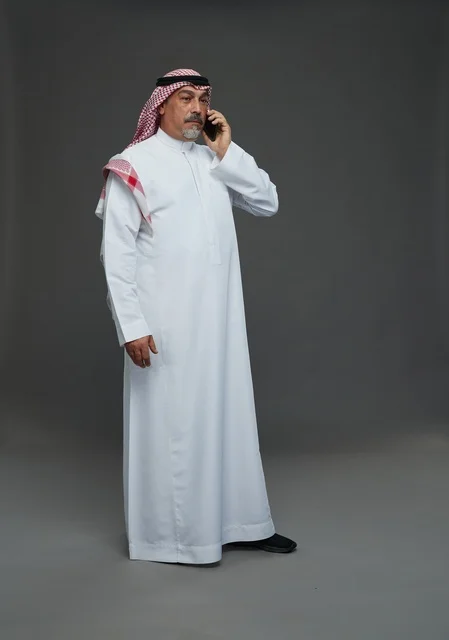 رجل سعودي مسن يتحدث بالهاتف في استوديو