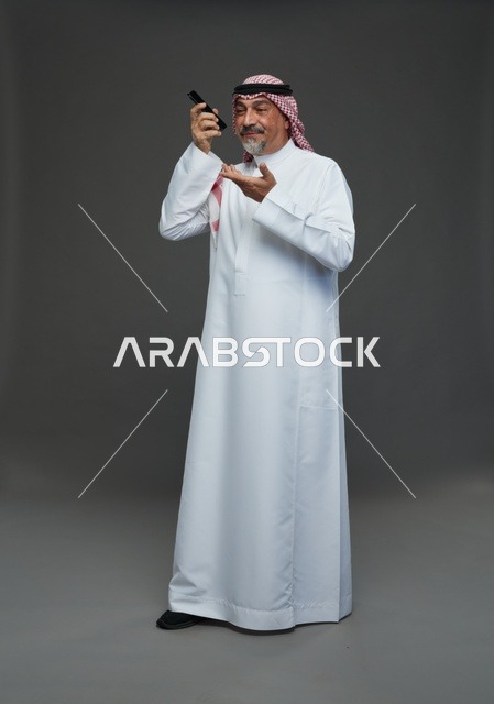 Elderly Saudi Man Smiling on Mobile Phone