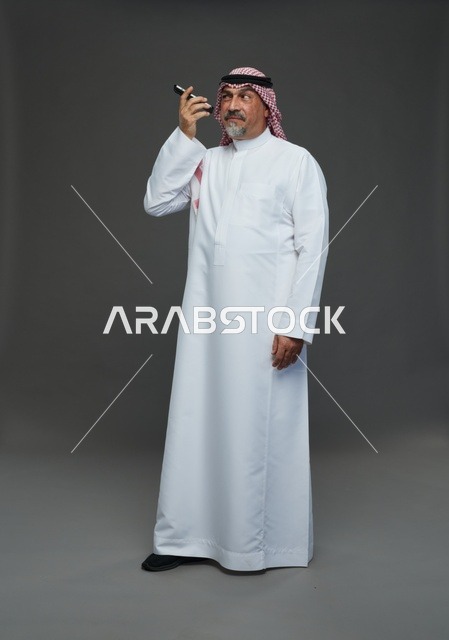 رجل سعودي مسن يتحدث بالهاتف في استوديو