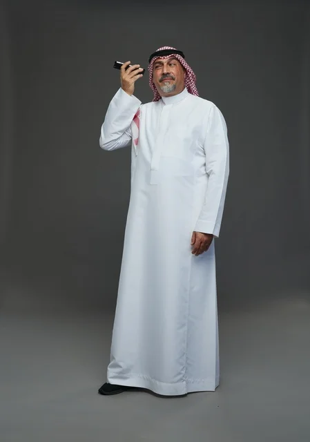 Elderly Saudi Man Using Smartphone on Grey Background