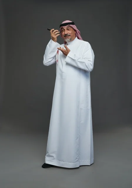 Elderly Saudi Man Smiling with Smartphone Studio Shot