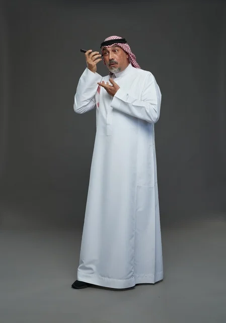 رجل سعودي مسن يستمع لرسالة صوتية بالهاتف