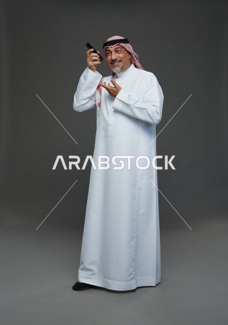Senior Saudi Man Smiling While Using Smartphone