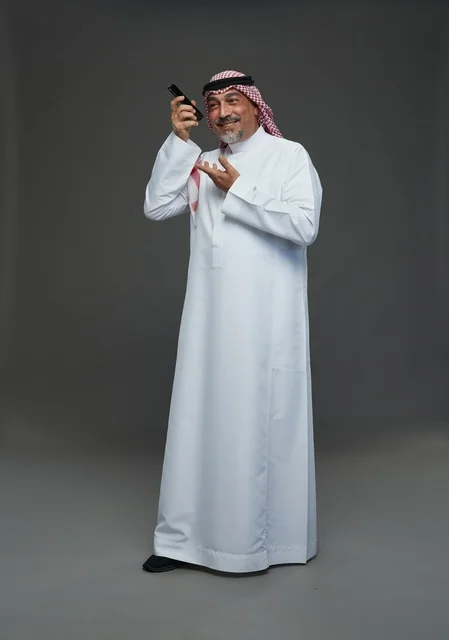 Senior Saudi Man Smiling While Using Smartphone