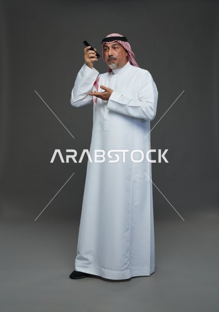 رجل سعودي مسن يتحدث بالهاتف في استوديو